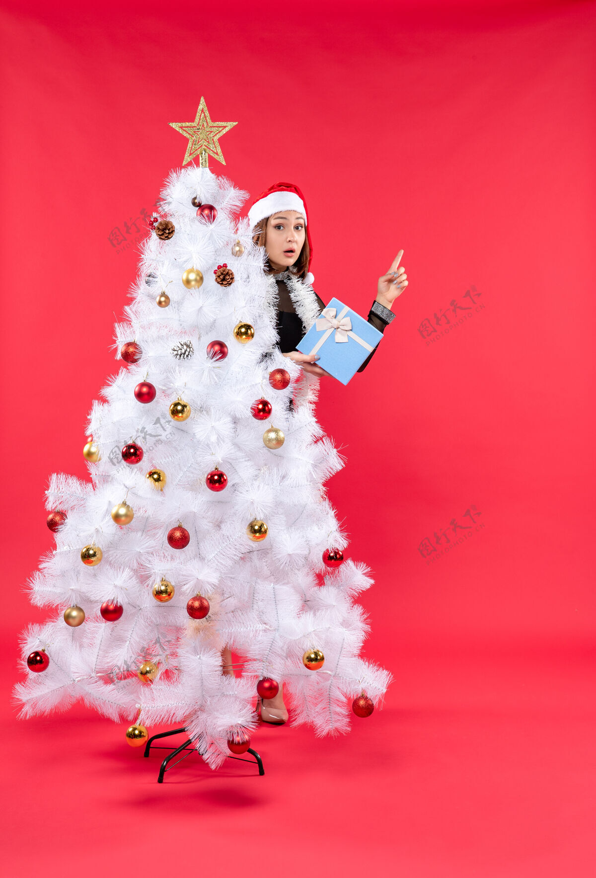 心情圣诞气氛的俯视图 美丽的女孩穿着黑色连衣裙 戴着圣诞老人的帽子圣诞老人帽子圣诞