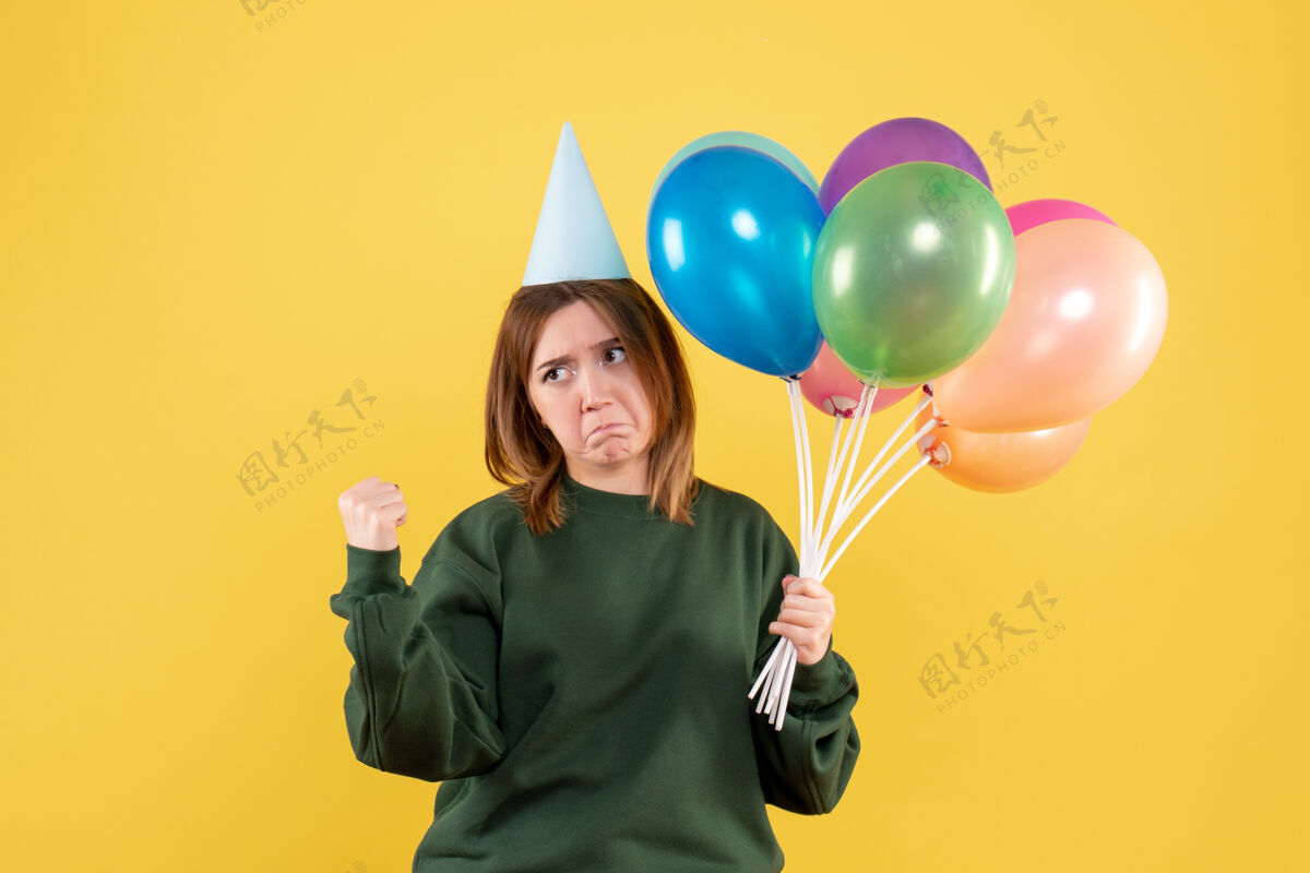 人正面图是一位年轻的女士 手里拿着五颜六色的气球年轻的女人生日气球