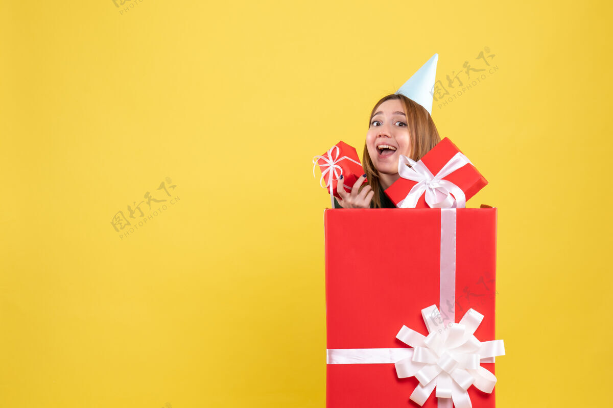 圣诞节正面图年轻女子躲在里面呈现人礼物隐藏