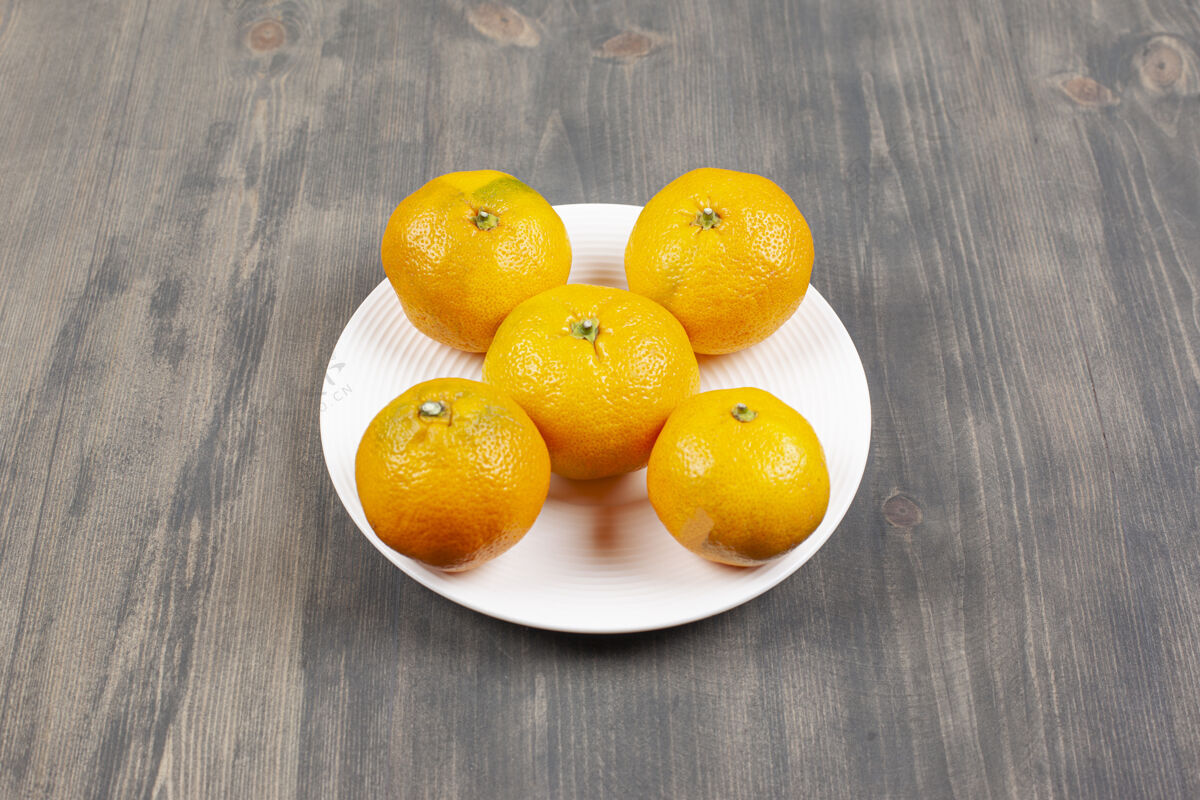 美味一个白色的盘子里装满了甜甜的新鲜橘子高质量的照片美味盘子柑橘