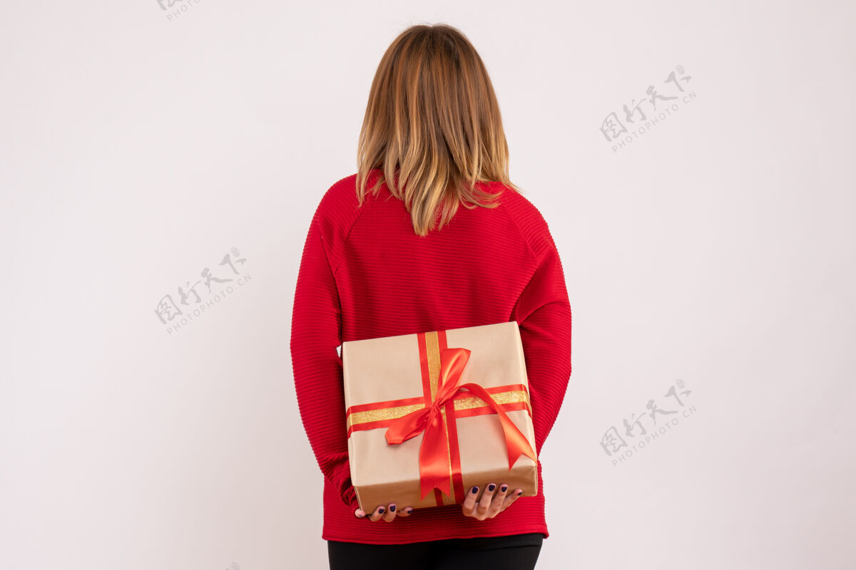 人正面图：年轻的女性把礼物藏在背后女人年专业