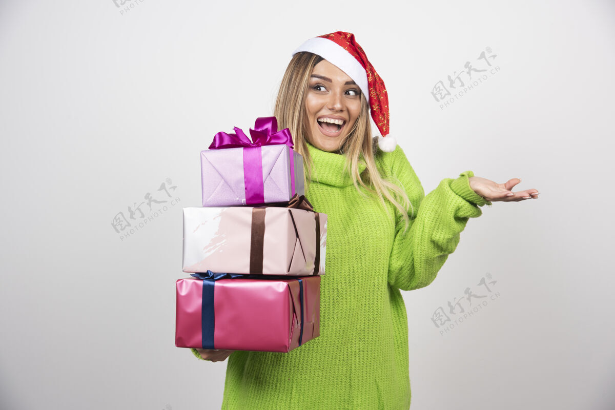 人类年轻微笑的女人手里拿着圣诞礼物圣诞老人节日人
