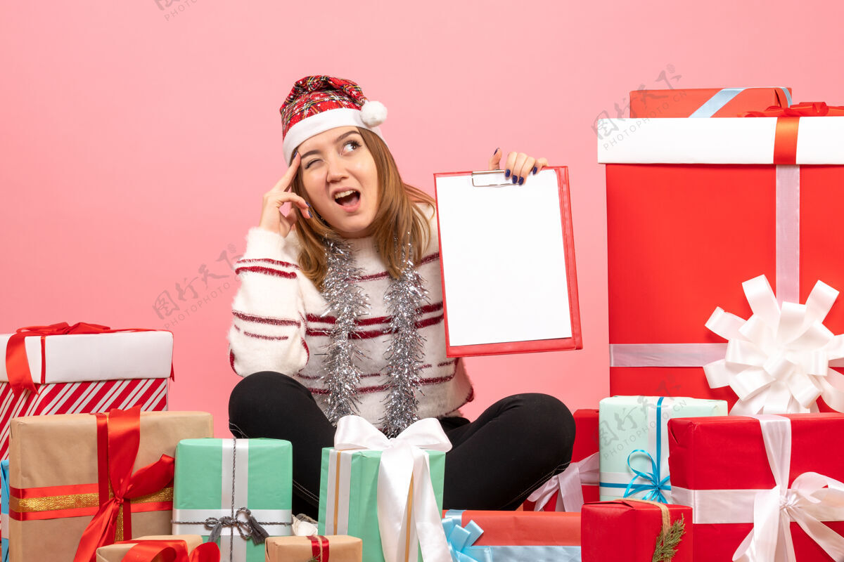 情感前视图年轻女性围坐在圣诞节礼物与文件说明粉色盒子圣诞节