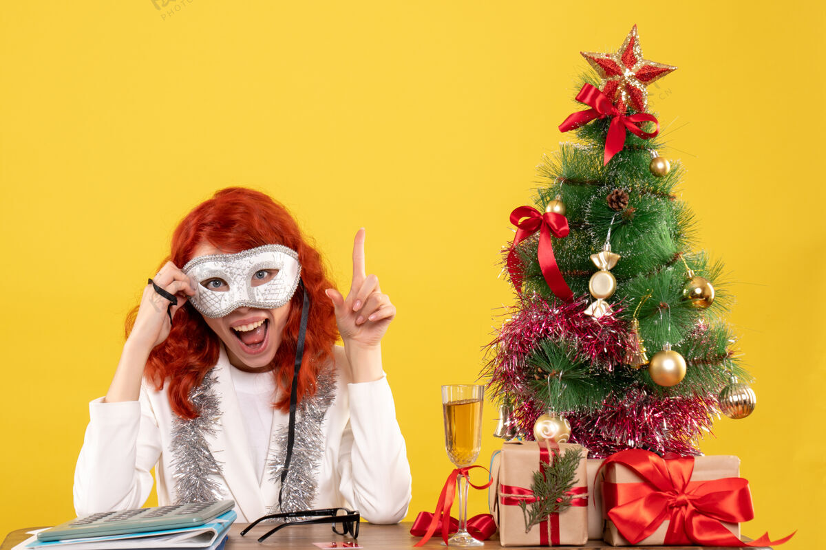 黄色女医生戴着面具围着圣诞树 黄色的礼物医生成人圣诞节