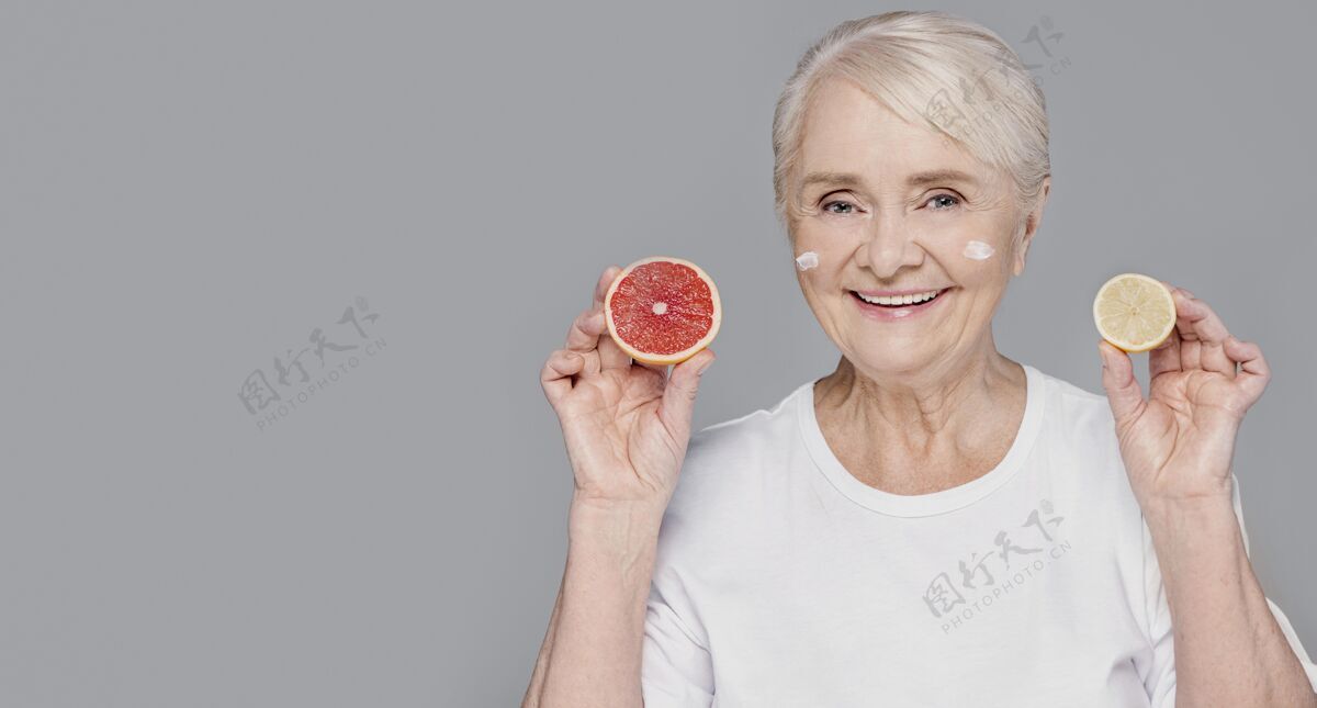 老年人拿着柑橘的中枪女人灰色女性水平