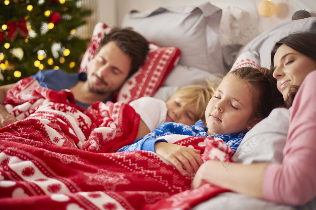 睡觉一家人在圣诞节早上睡觉圣诞装饰儿子女孩