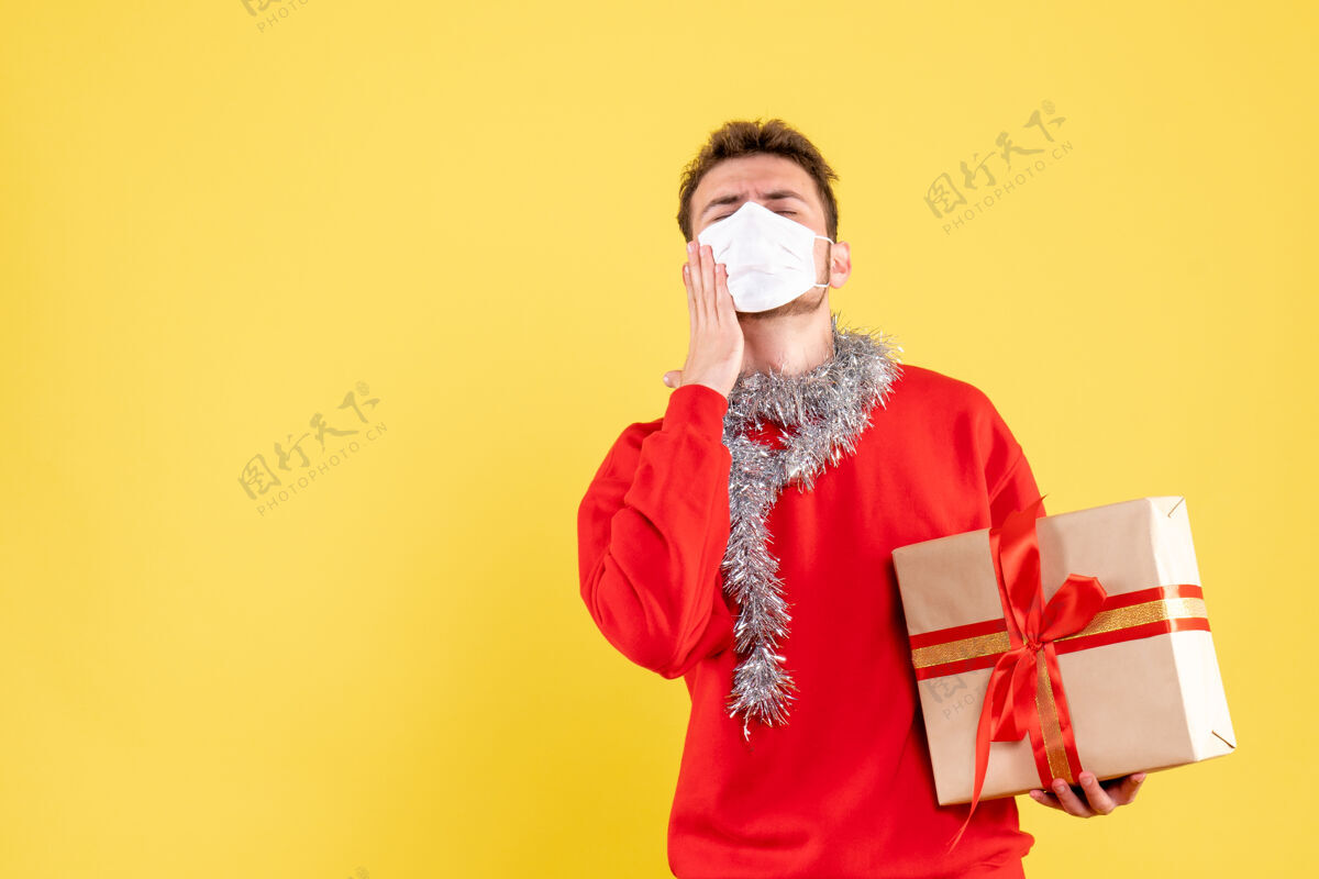 颜色正面图：戴着无菌面具的年轻男性正在过圣诞节不育成人年轻