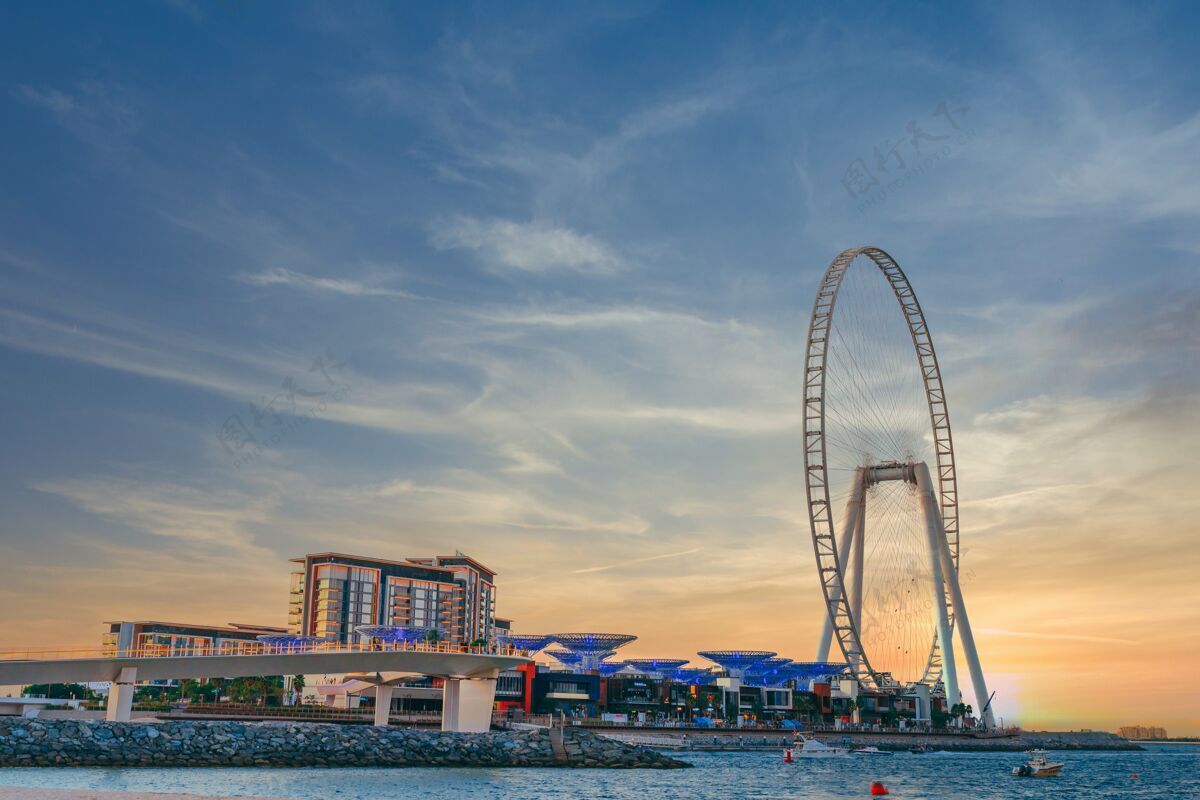 海滩低角度拍摄的现代设计与一个巨大的摩天轮在迪拜的蓝水岛建设景点建筑岛屿