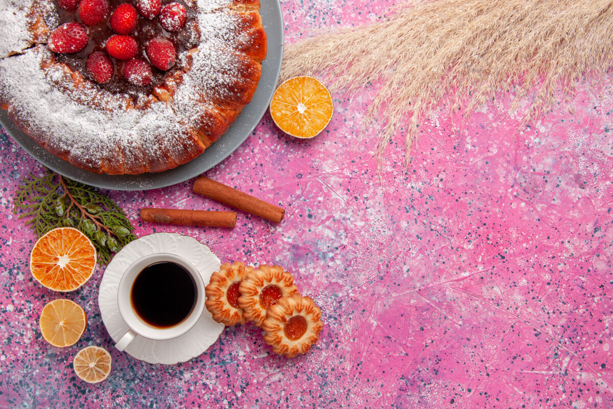 派俯瞰美味的草莓蛋糕 配上糖粉饼干和茶 背景为浅粉色蛋糕 甜甜的糖饼干饼干馅饼热的咖啡蛋糕