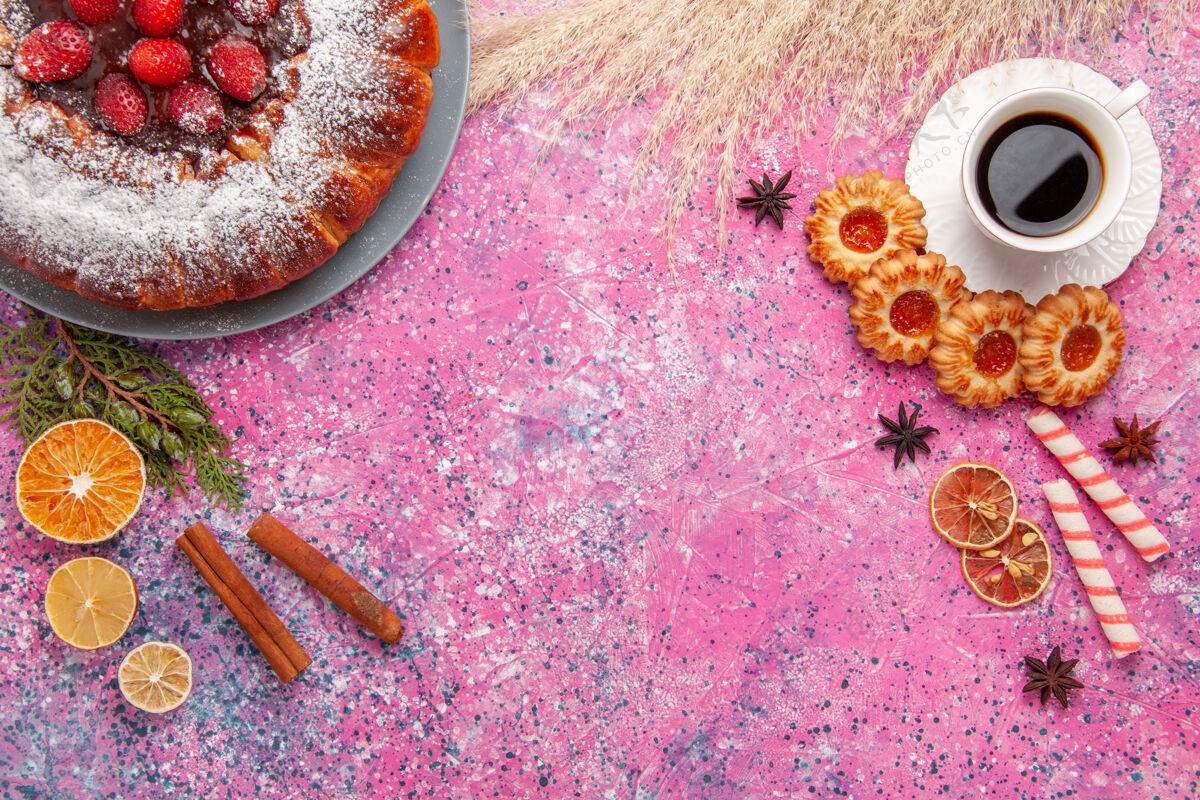 生的俯瞰美味的草莓蛋糕与饼干和一杯茶的粉红色背景蛋糕烘烤甜甜饼干饼干饼干派烹饪五颜六色派