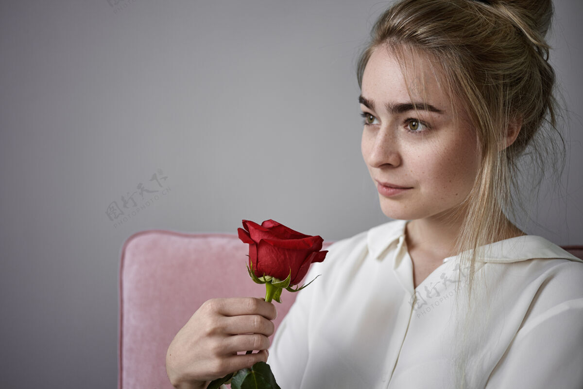 脸浪漫 爱情和自然美的概念情人节这天 美丽浪漫的年轻女性 金发 白衬衫 孤独地坐着 闻着红玫瑰魅力年轻放松