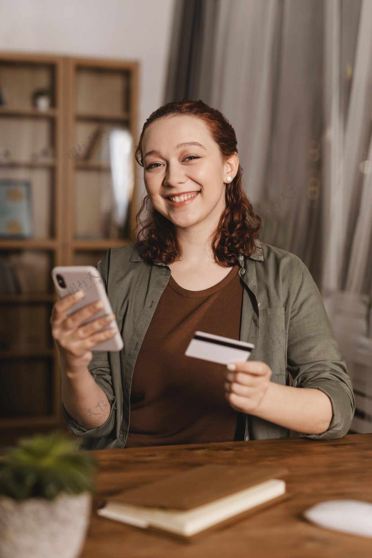 人笑脸女人在家里用信用卡和智能手机智能手机人人类