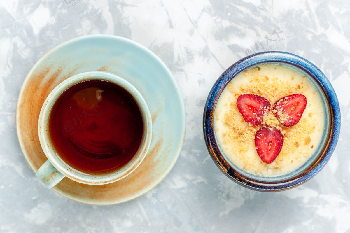 草莓俯瞰美味的奶油甜点 配上新鲜草莓和茶 背景为浅白色 甜点冰激凌 水果味甜美甜点咖啡视野