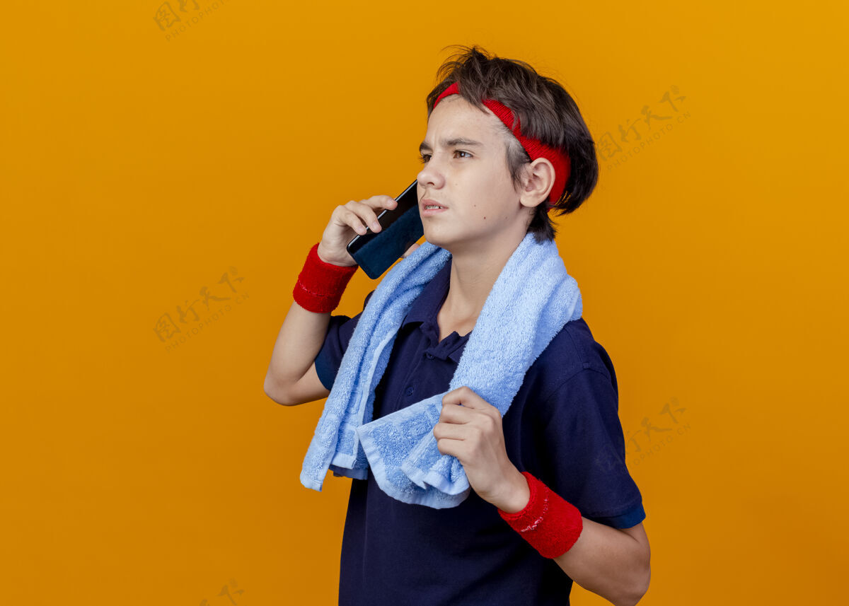 运动皱眉的年轻帅气的运动男孩在打电话腕带年轻说话
