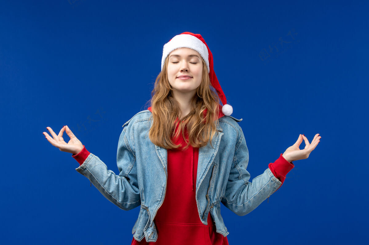 圣诞节正面图年轻女性沉思蓝色背景情感圣诞假期色彩女性人前面