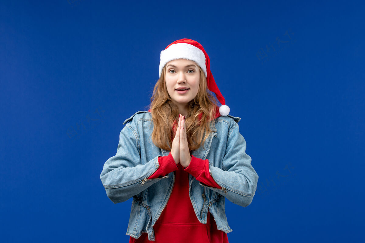 祈祷前视图年轻女性在蓝色背景上祈祷情感圣诞假期色彩蓝色观点快乐