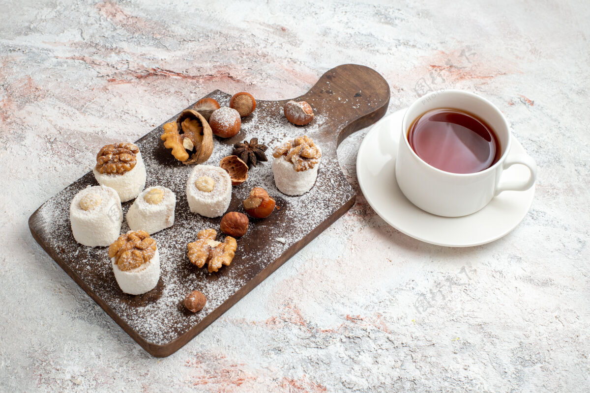 生的半俯视小蛋糕 核桃 一杯茶和榛子 在白色表面坚果蛋糕饼干糖甜饼干咖啡榛子饼干