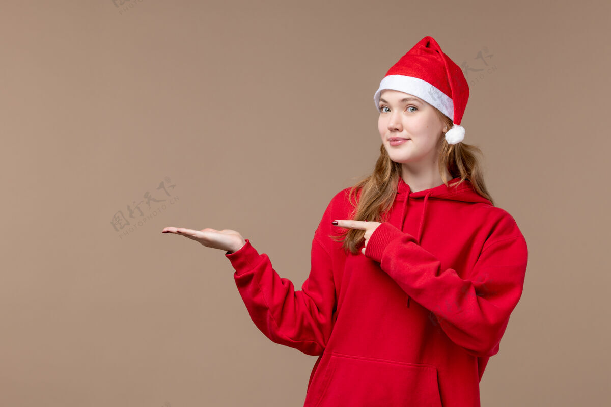 职业正面是棕色空间上穿着红色斗篷的圣诞女孩制服女孩帽子