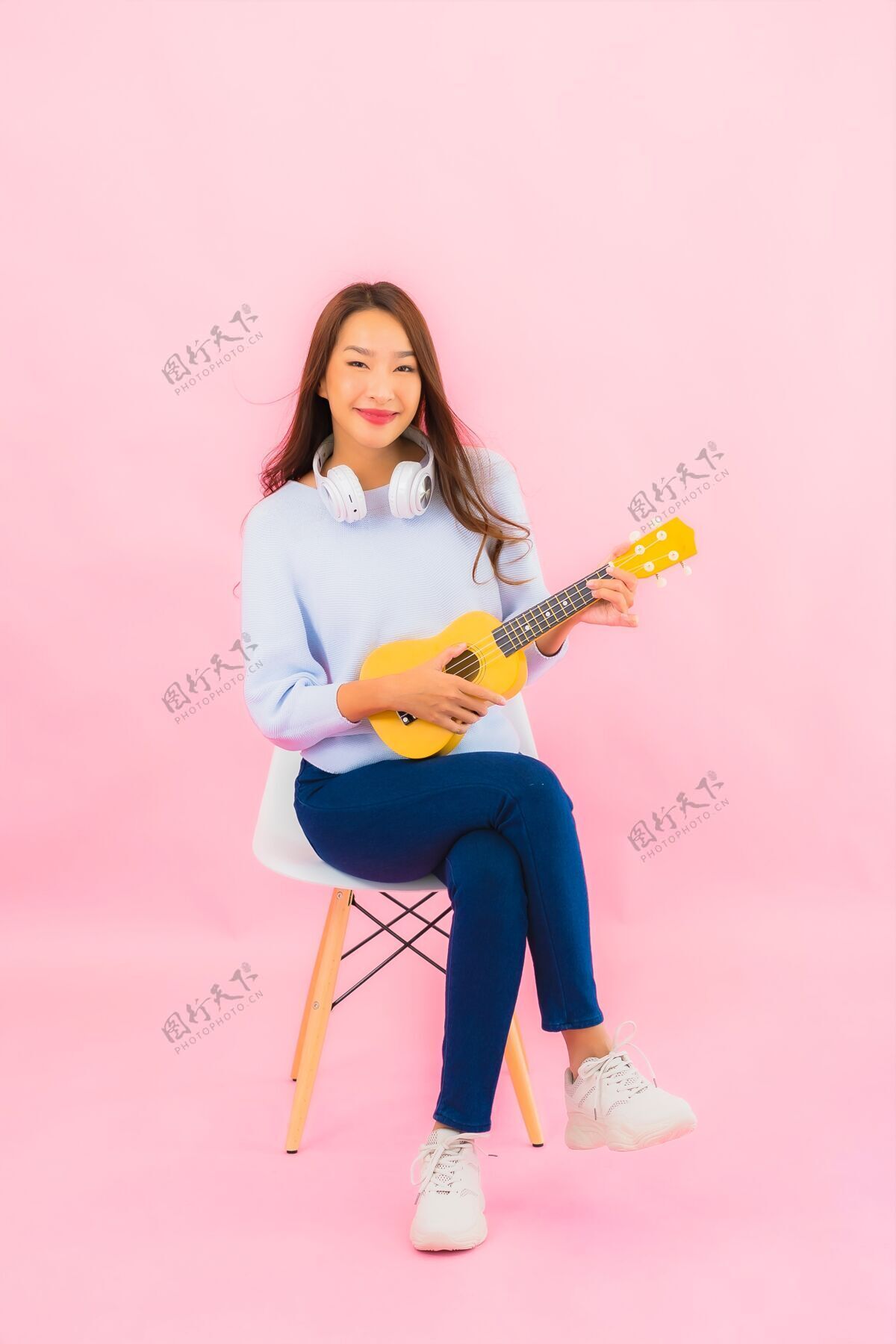年轻肖像美丽的亚洲年轻女子在粉红色的隔离墙上演奏四弦琴可爱的女孩演奏女人