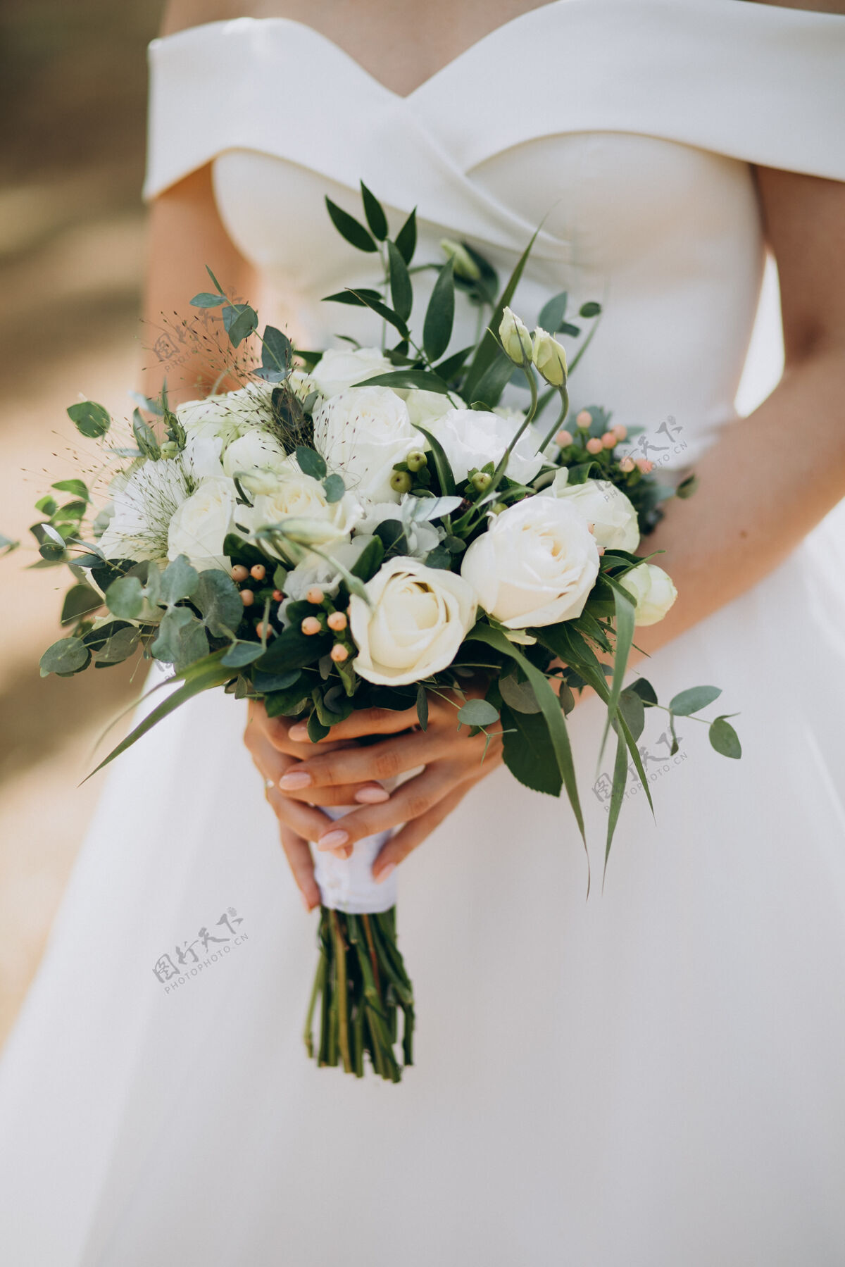礼服新娘手持她的婚礼花束花束安排开花