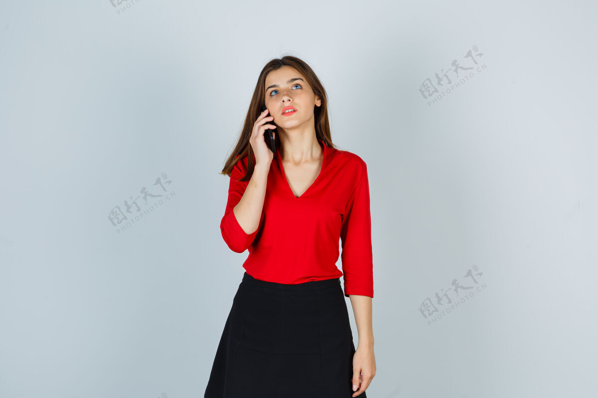 体贴穿着红衬衫 裙子 正在打电话的年轻女士看起来很体贴年轻肖像美丽