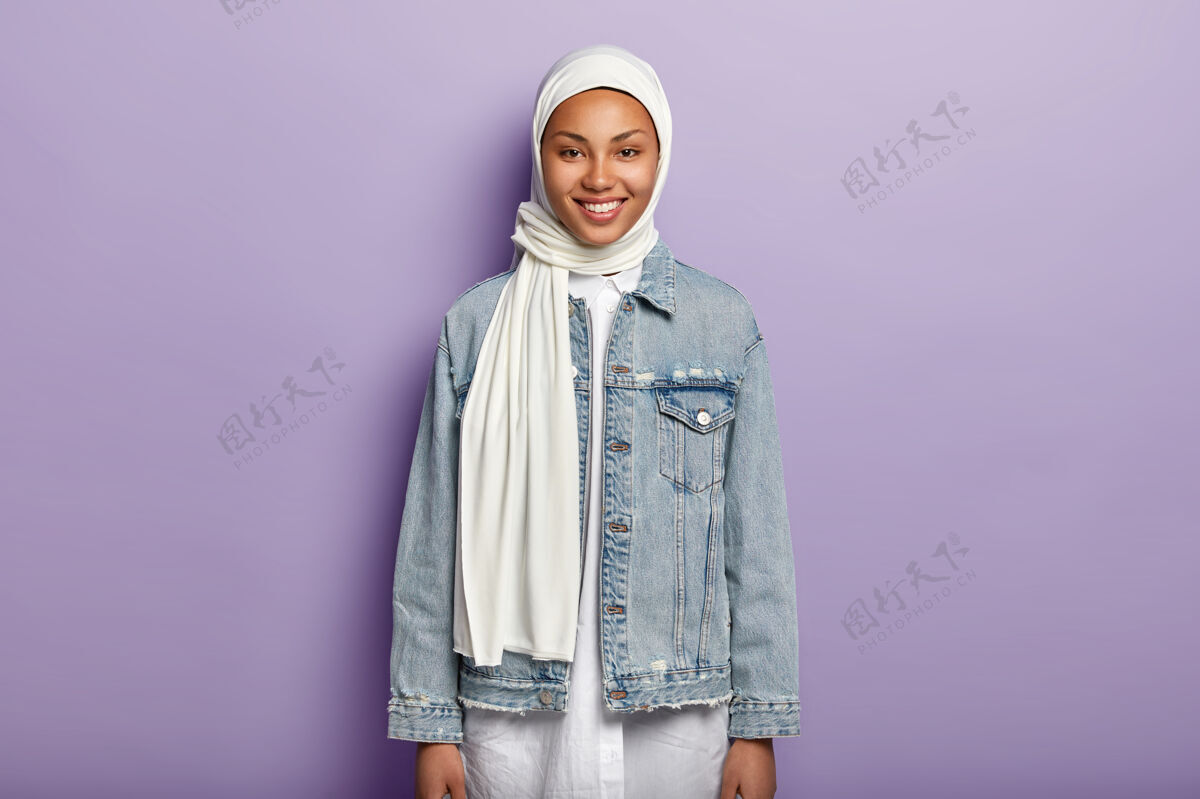 服饰半长镜头的阿拉伯女人戴着白色头巾 牛仔夹克女士眉毛牛仔裤