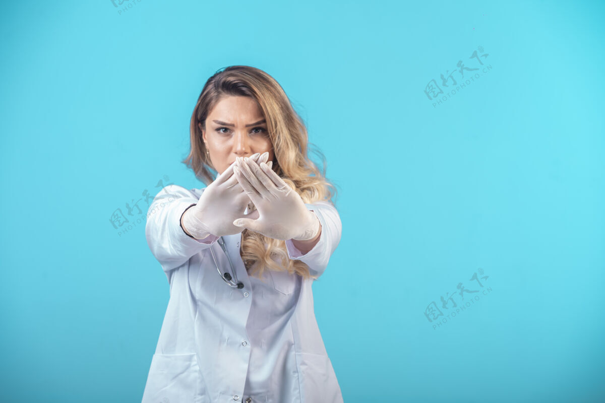 模特穿白色制服的女医生在阻止什么无菌临床摆姿势
