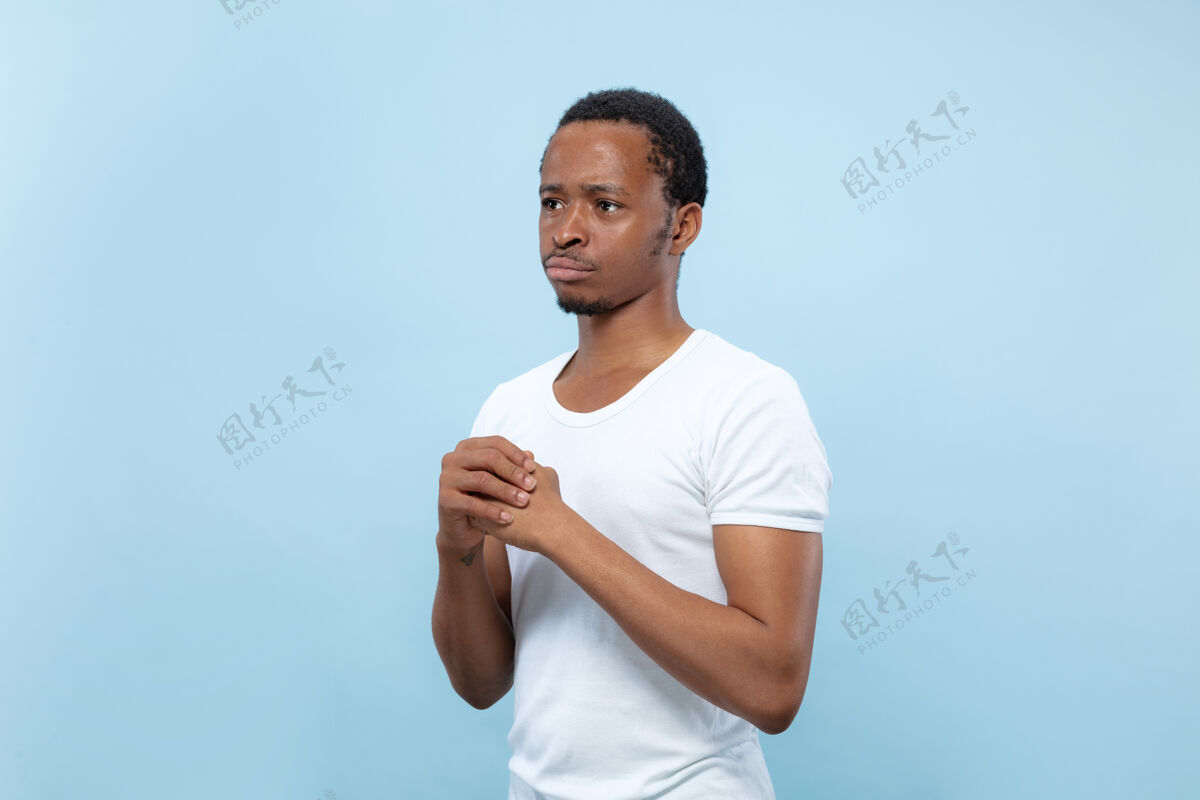 表情穿着白衬衫的年轻非洲裔美国男模的特写肖像疑惑 询问 表现不确定性 深思熟虑人顺序怀疑