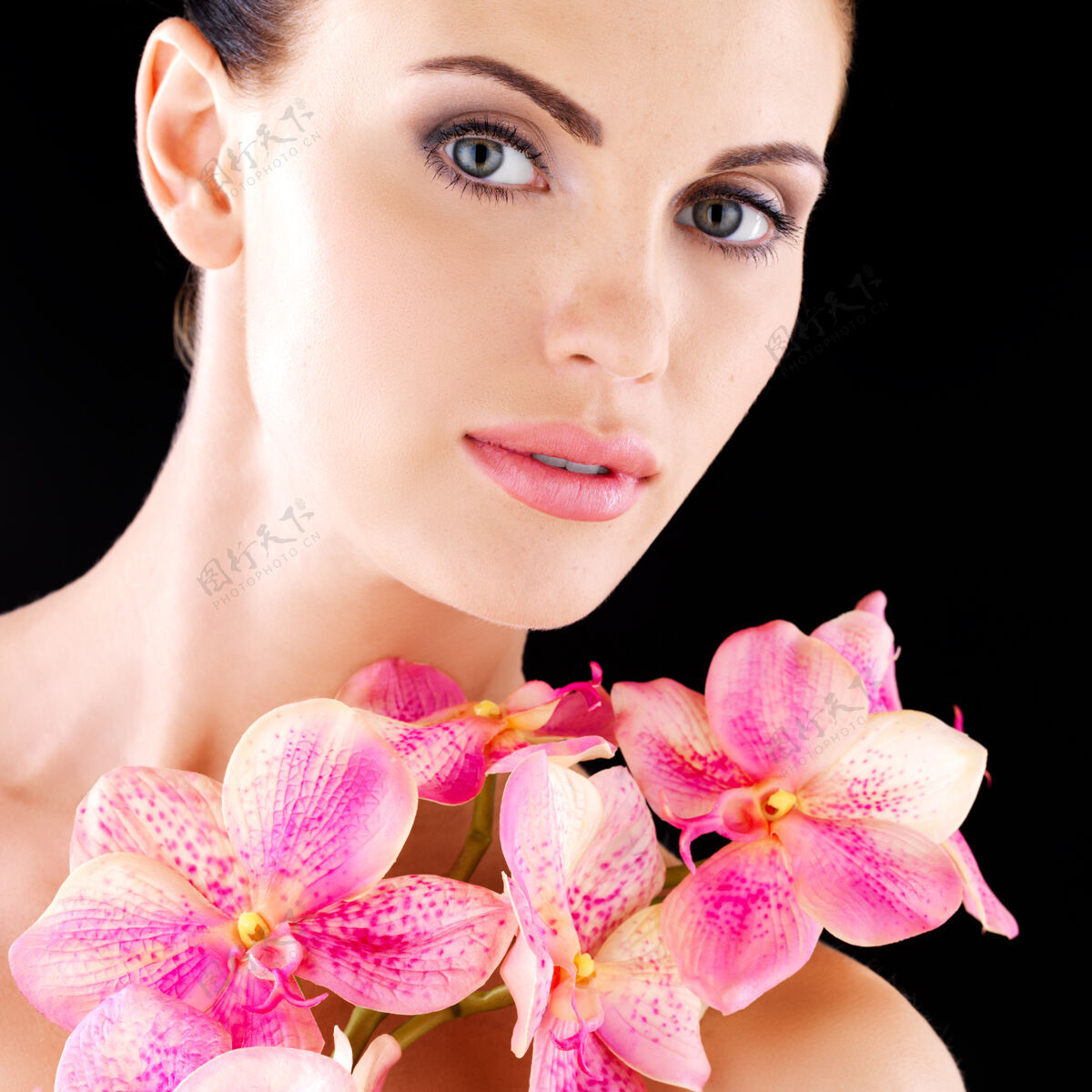 干净一个拥有健康皮肤和粉色花朵的成年女性的美丽脸庞-工作室背景皮肤护理美容治疗