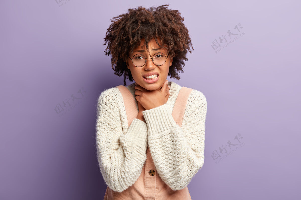 沮丧不高兴的黑皮肤女人患有窒息症 双手放在喉咙上 咬紧牙关 有卷曲的非洲头发理发消极颈部