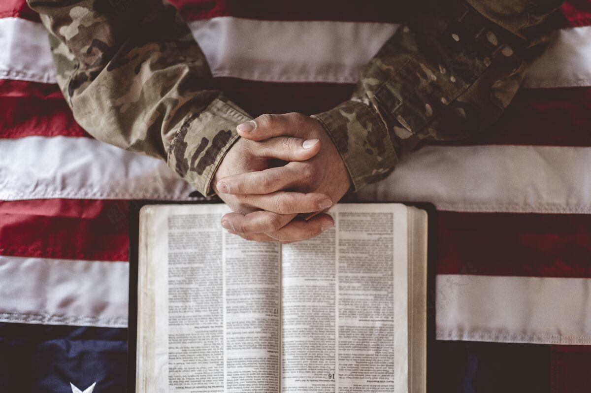军官一名美国士兵在美国国旗和圣经面前哀悼和祈祷团结服务军队