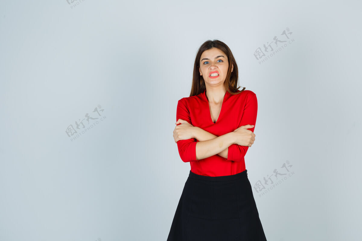 女人穿红衬衫 黑裙子的年轻女子交叉双臂站着 看上去很生气问题坏情绪