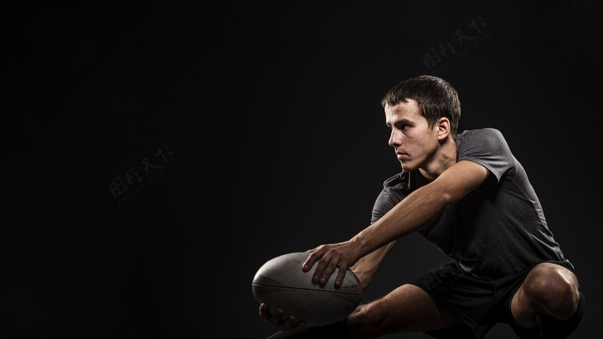 比赛帅气的运动男橄榄球手拿着复制空间的球球空间球员