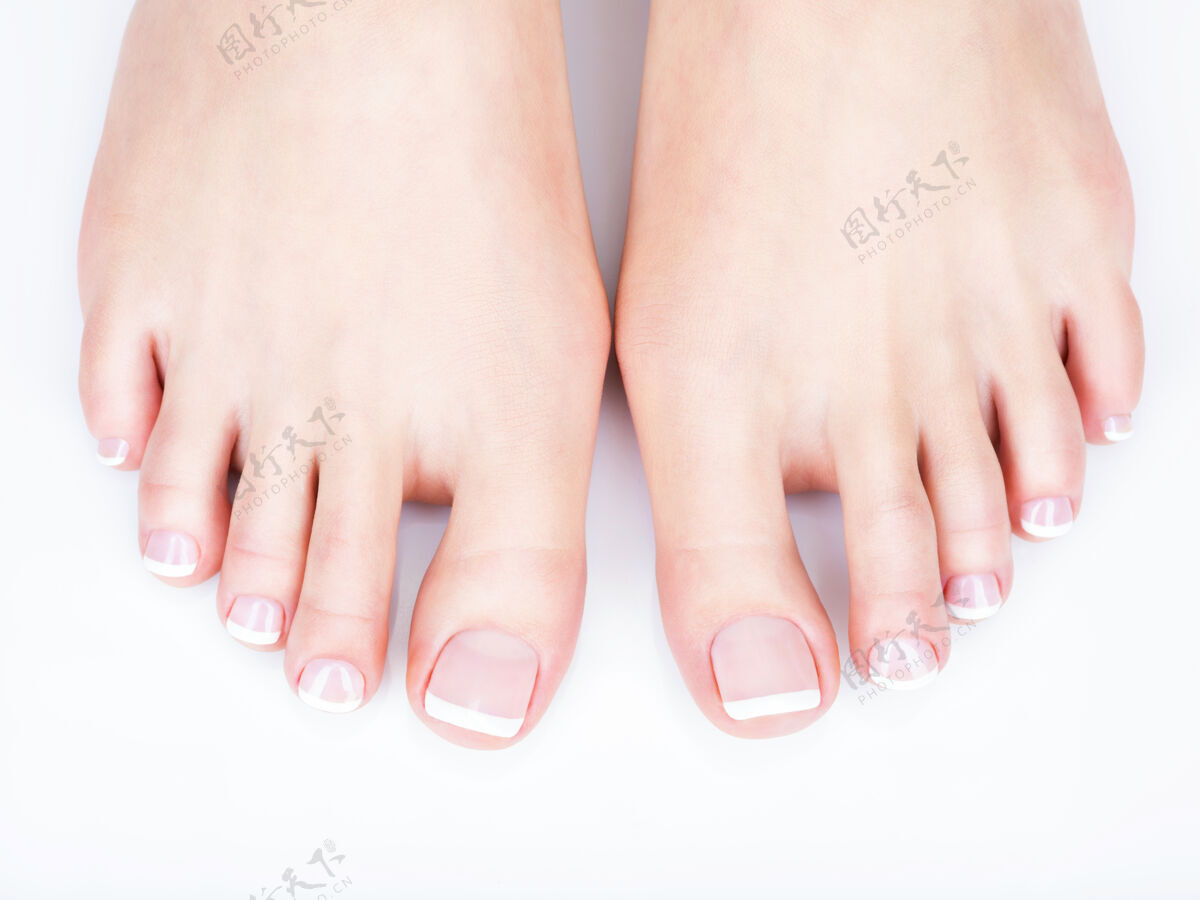 足疗特写照片的一个女性脚与白色法国足疗指甲身体按摩治疗