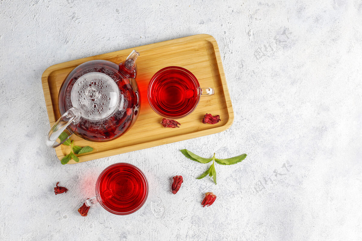 香料热木槿茶在一个玻璃杯子和玻璃茶壶茶健康排毒