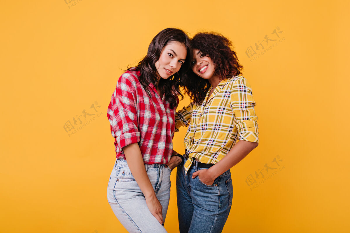 酷深色短发的女孩们神秘地看着穿着彩色衬衫的女士们互相拥抱肖像夏天朋友
