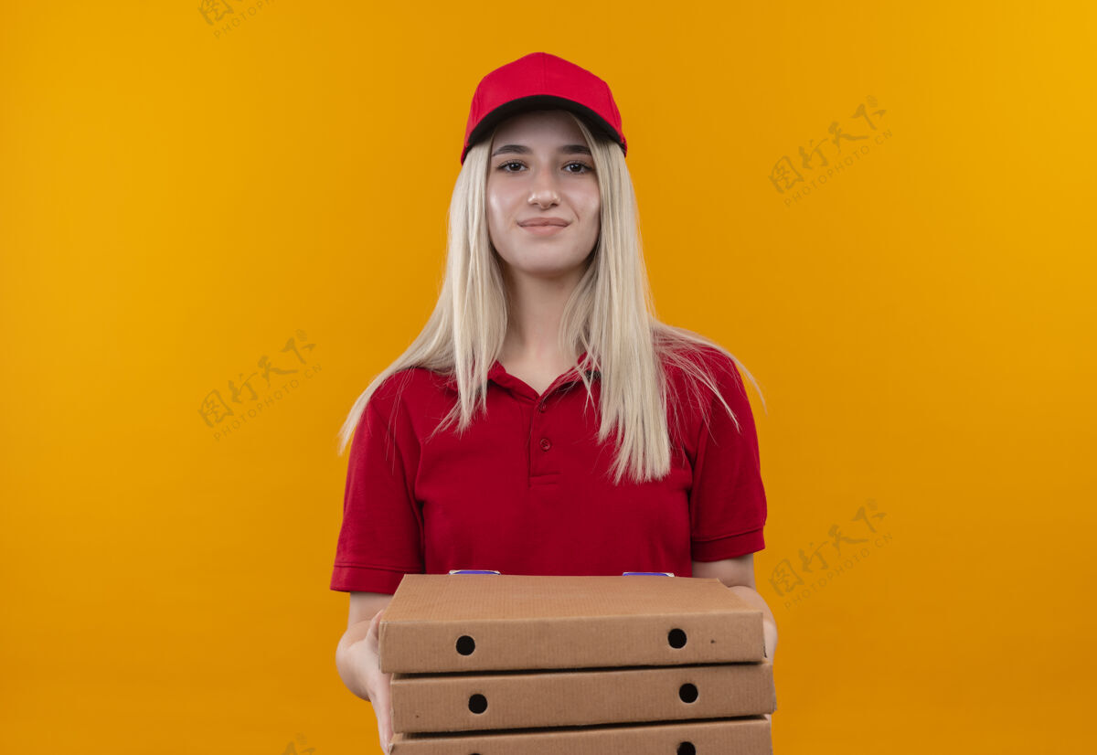 T恤一个年轻女孩穿着红色t恤 戴着帽子 拿着披萨盒 背景是孤立的橙色红色年轻高兴