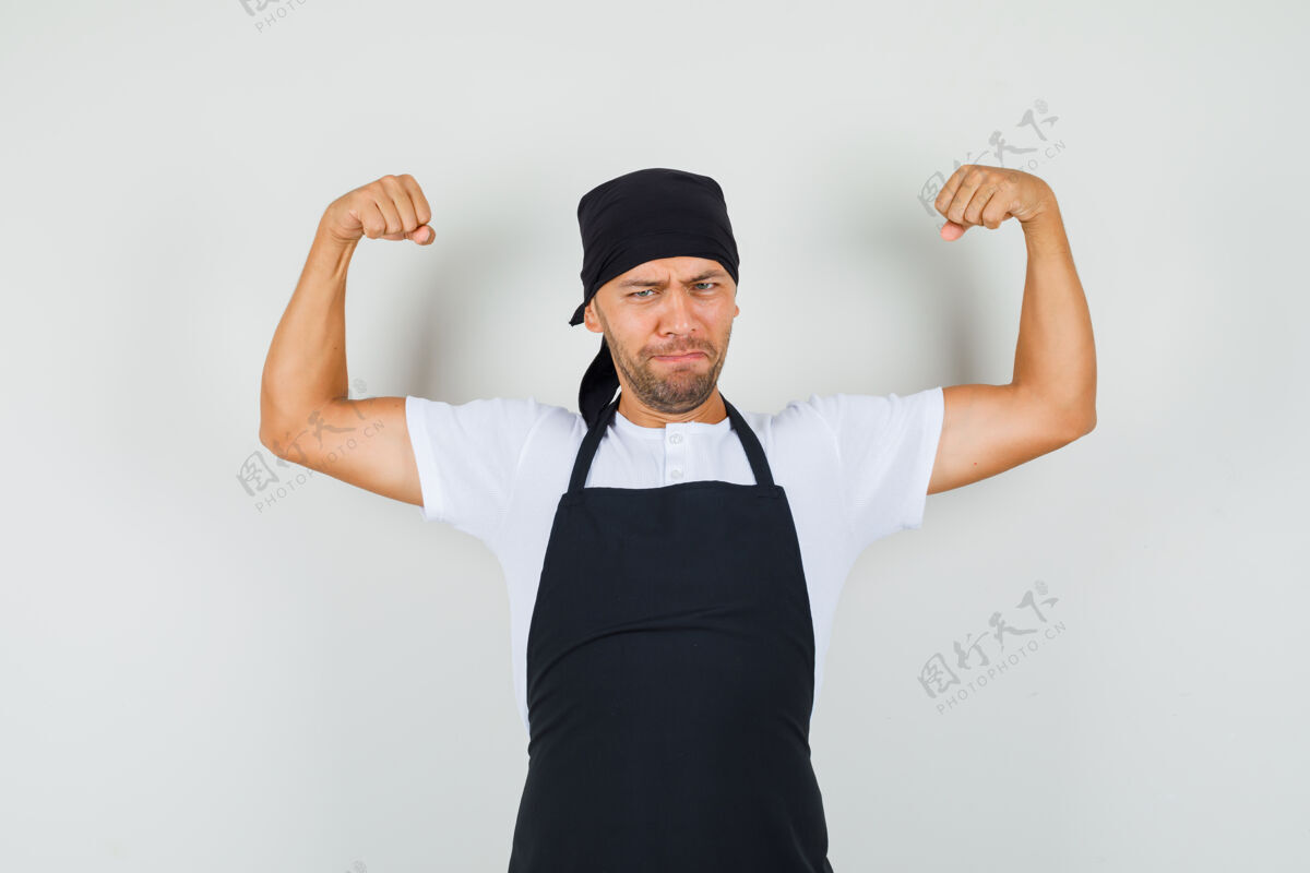 糕点面包师身穿t恤 围裙 展示手臂肌肉 看上去很有力量面包师面包年轻
