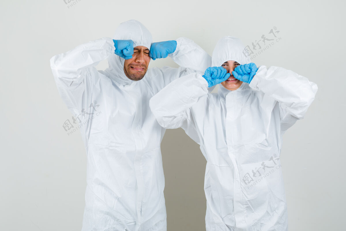 人两个医生穿着防护服 戴着手套揉着眼睛 哭得像个孩子 看起来很害怕医生诊所医学