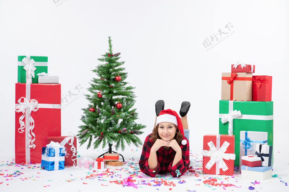 树正面图年轻女性躺在圣诞礼物和圣诞树上 白色背景礼物圣诞新年彩雪雪礼物周围