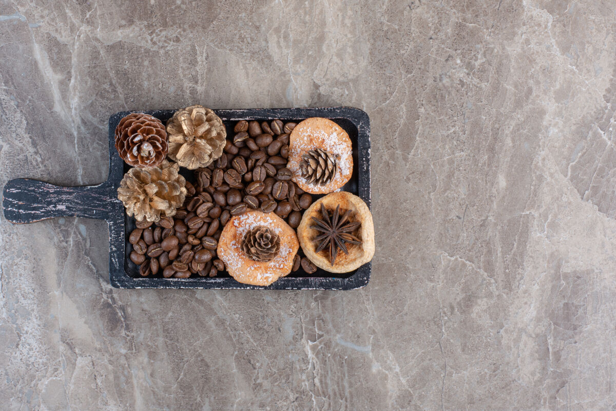 美味八角 曲奇 咖啡豆和松果放在大理石上视图曲奇针叶树