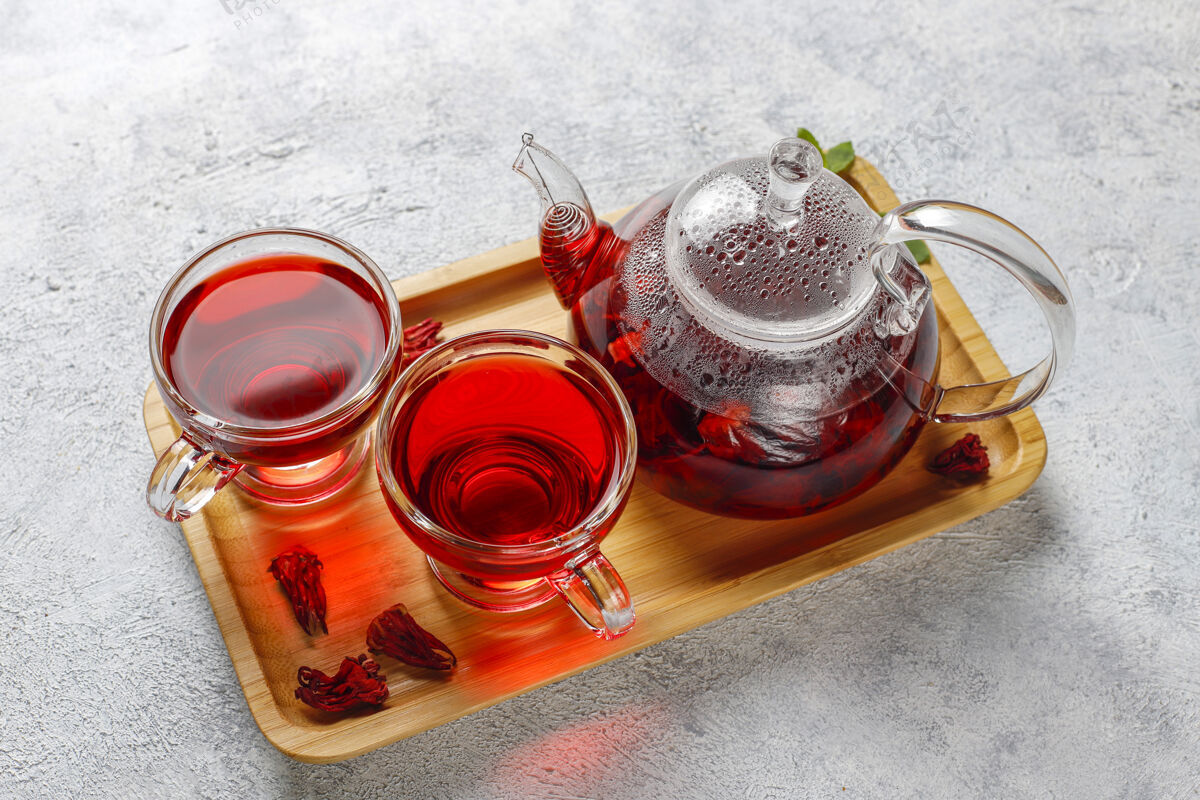 传统热木槿茶在一个玻璃杯子和玻璃茶壶植物玻璃热
