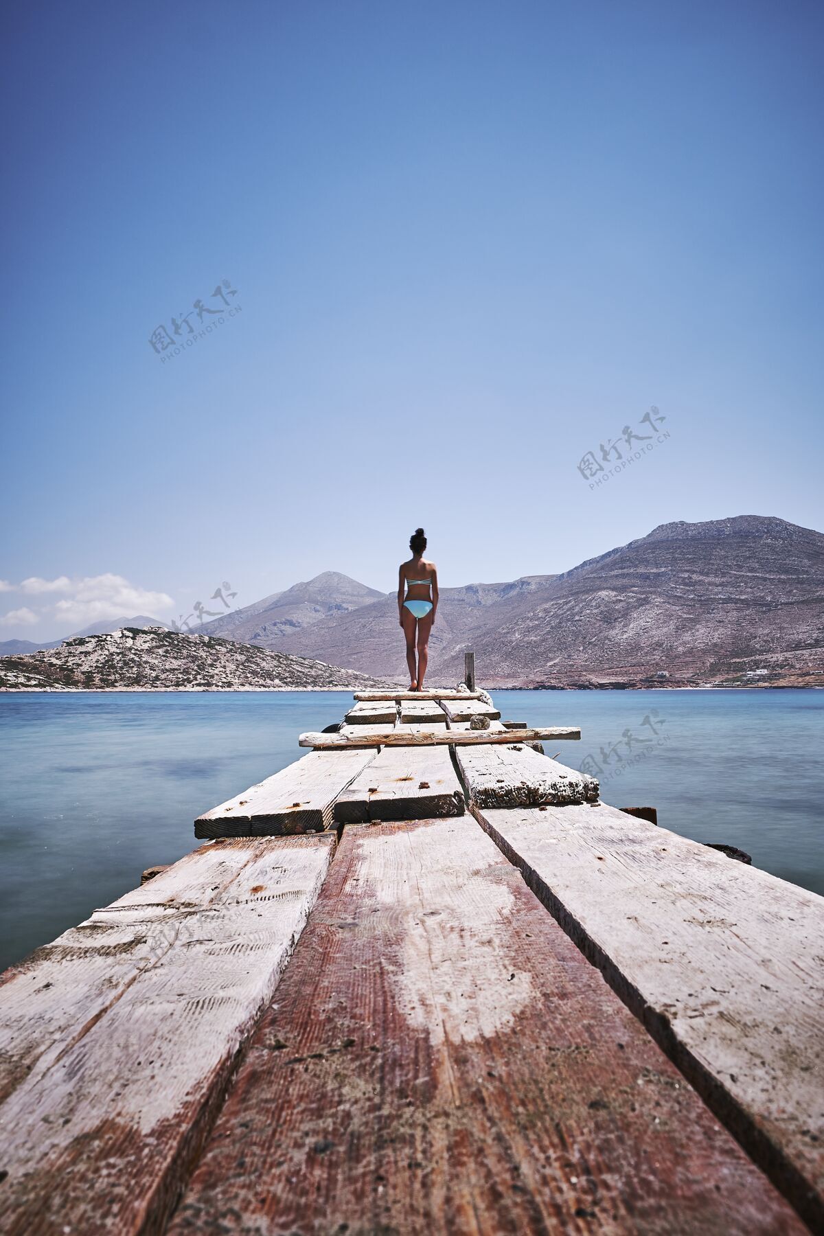 户外希腊阿莫戈斯岛 一名女性站在木质码头边的垂直镜头山港口墙