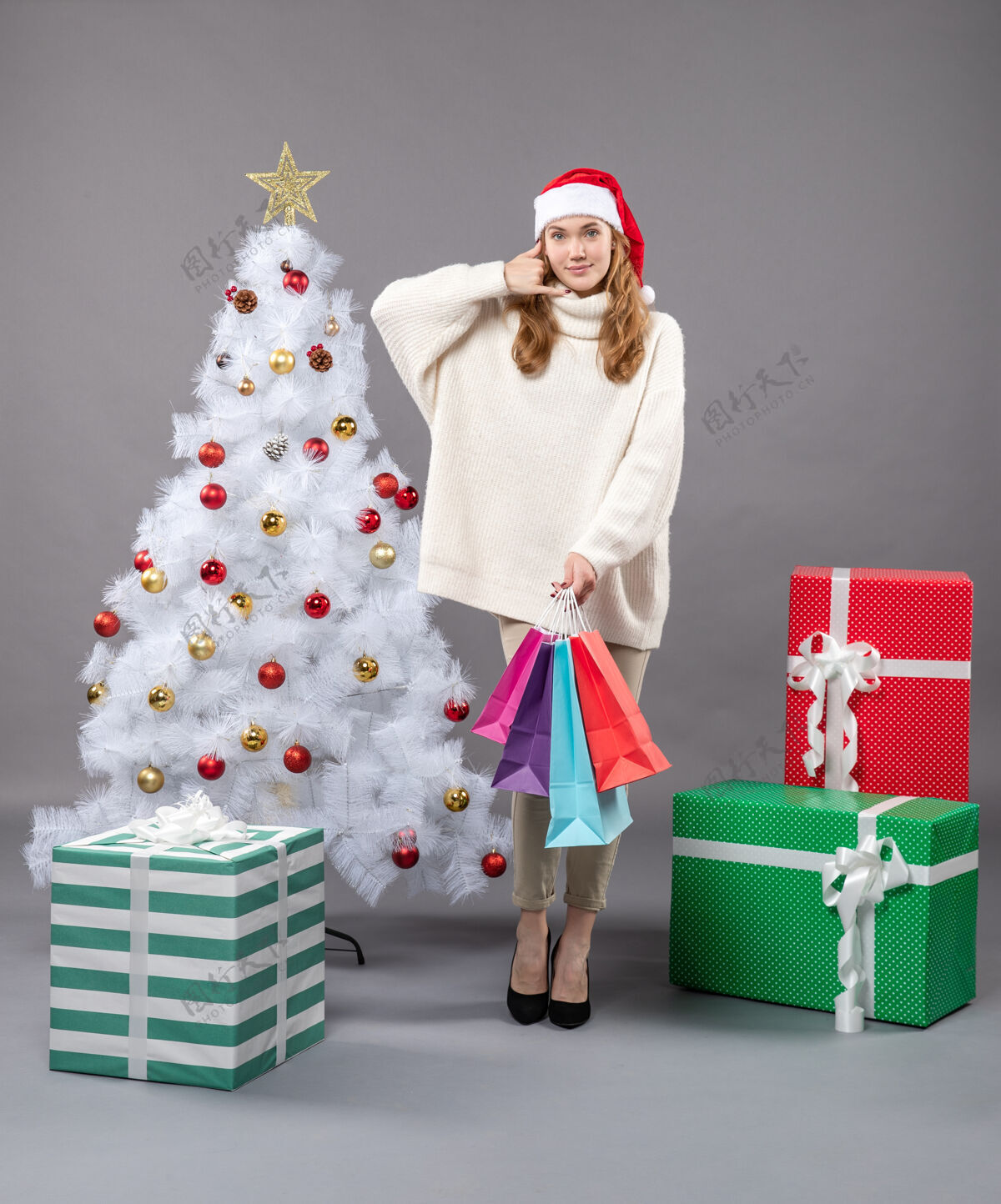 包前视图圣诞女孩与彩色购物袋显示呼叫我的电话标志人电话购物