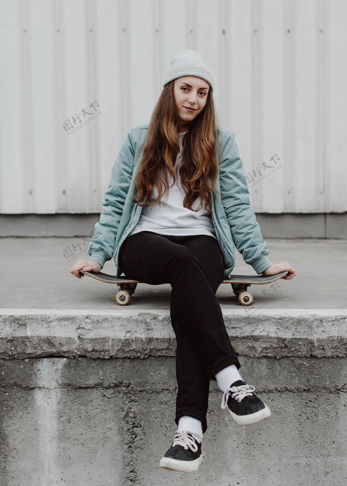 滑板城市里的溜冰女孩坐在溜冰板上生活日光城市