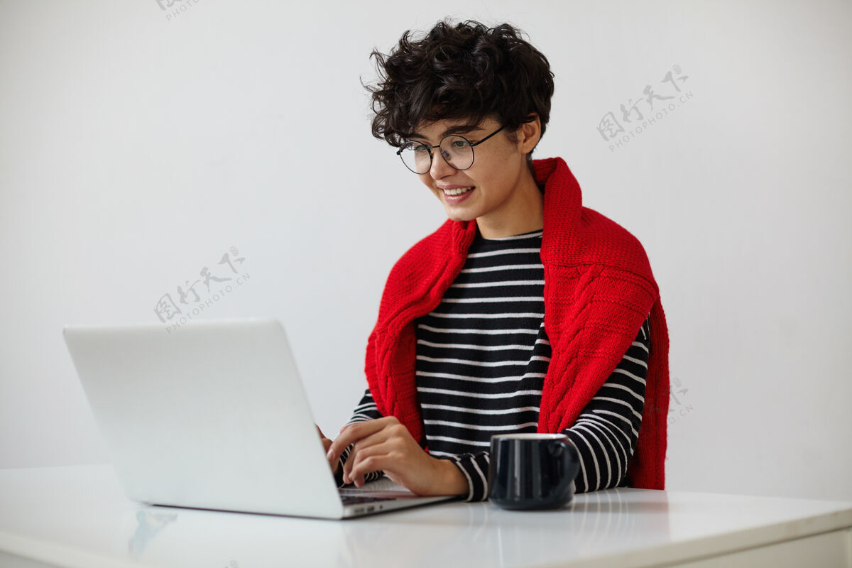 女商人室内照片迷人的年轻短发卷曲深肤色女性与自然化妆打字文本键盘上 微笑着看着屏幕 隔离在白色背景羊毛茶桌子
