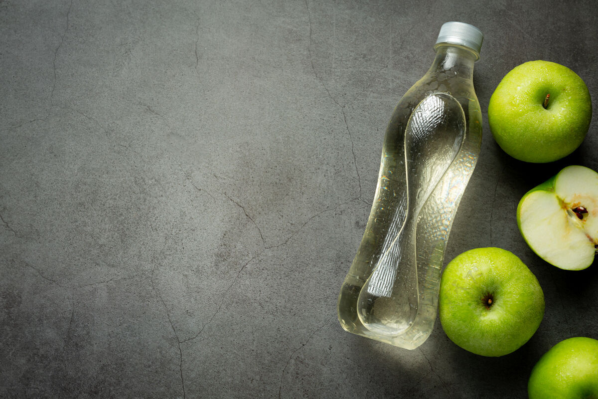 液体一瓶绿色苹果健康果汁放在新鲜的绿色苹果旁边草药玻璃杯冰沙