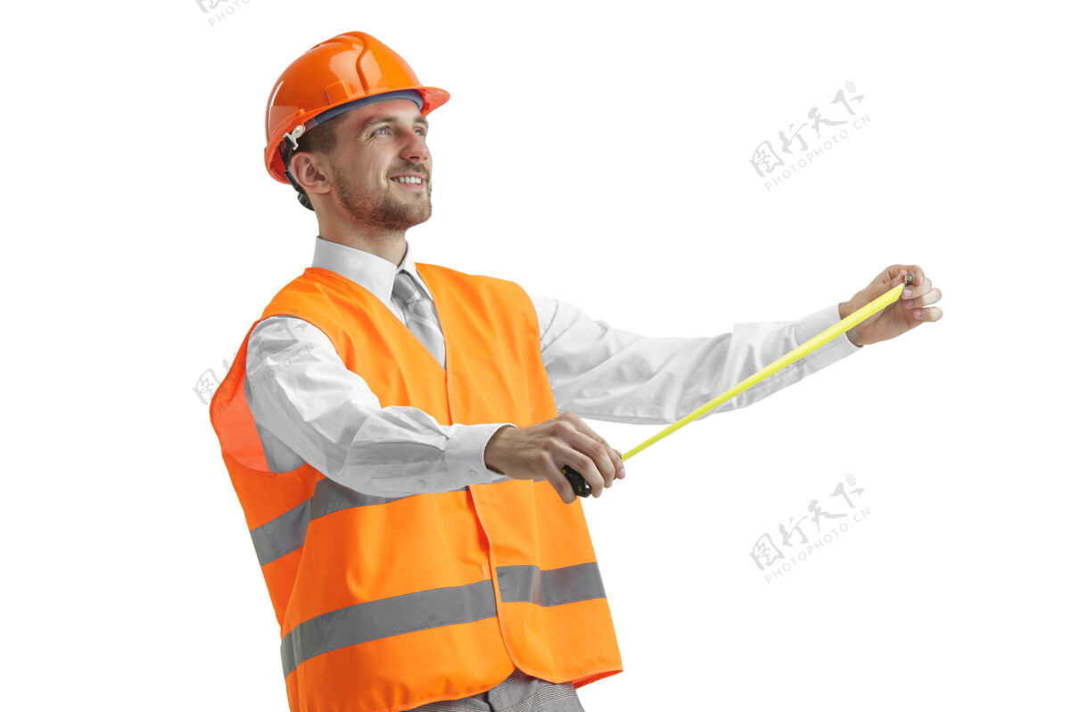 头盔穿着建筑背心和橙色头盔的建筑工人站在白色的工作室里工业工业男人