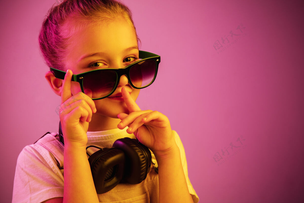 耳机霓虹灯下戴着耳机的年轻女孩的肖像 享受着音乐 呼唤着沉默耳机音频娱乐