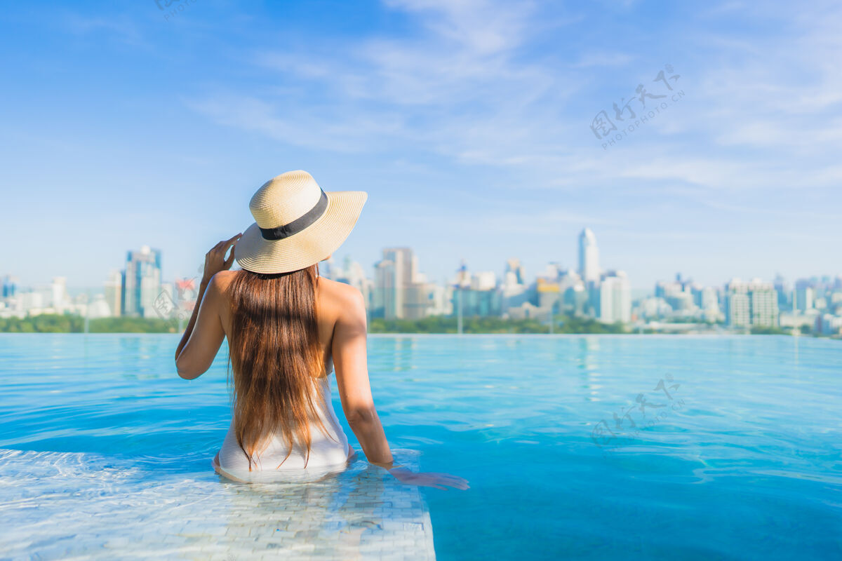 城市景观美丽的亚洲年轻女子在户外游泳池周围放松 城市景色尽收眼底中心塔楼豪华